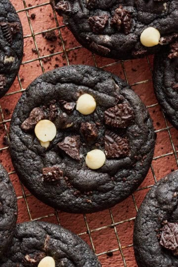 Chocolate Cookies and Cream Cookies on a cooling rack with crumbs sprinkled around.