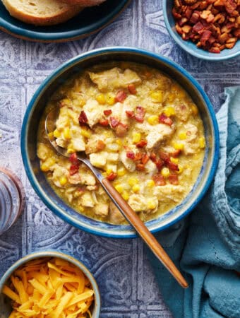 a bowl of chicken corn chowder with bacon bits on top