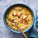 a bowl of chicken corn chowder with bacon bits on top