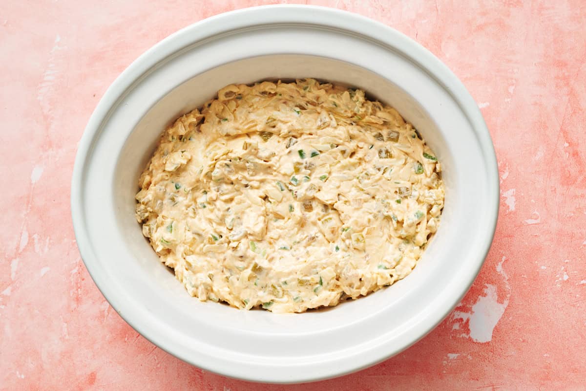 overhead of a crock pot filled with jalapeno popper dip before cooking