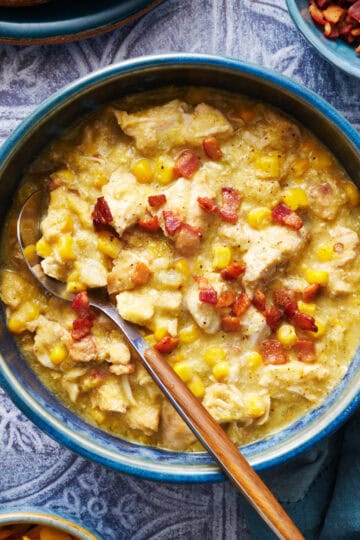 a bowl of chicken corn chowder with bacon bits on top