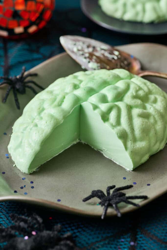 A green brain shaped jello dessert with a slice taken out