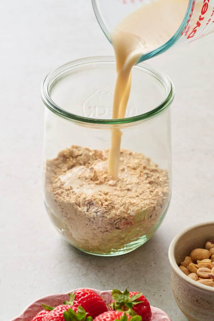 adding liquids to the dry ingredients with oats and protein powder