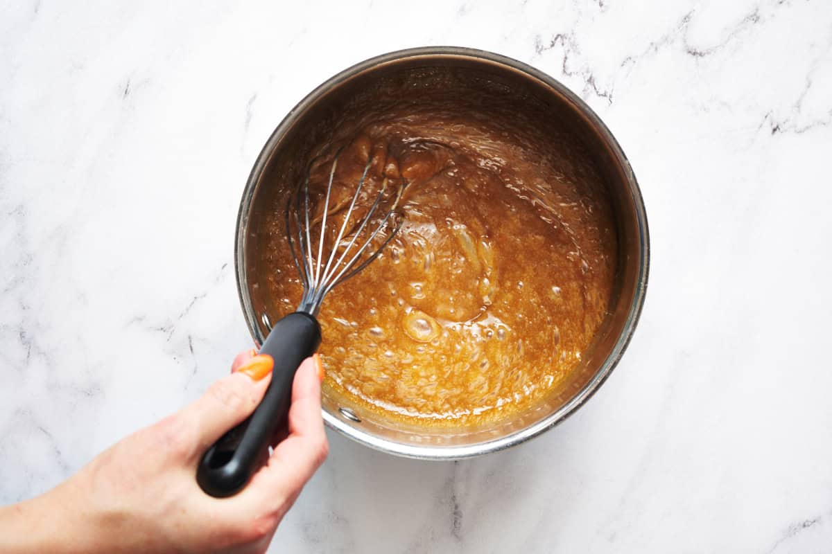 the hot sugar mixture with butter and corn syrup while it's still bubbling