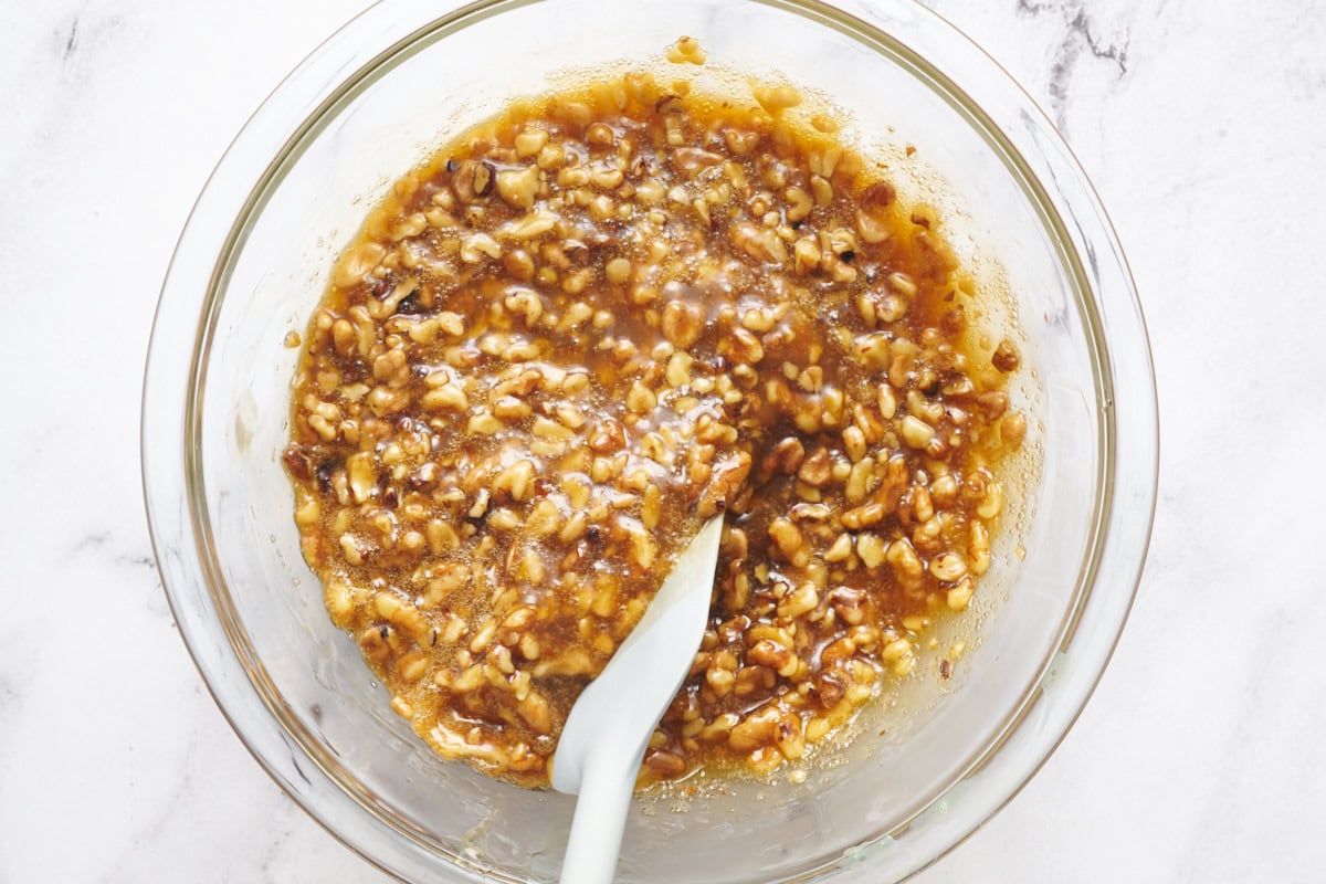 adding chopped pecans to pecan pie filling