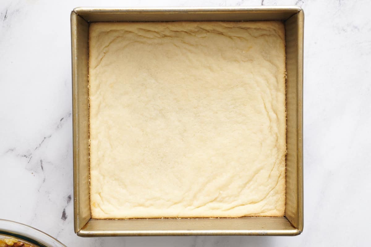 shortbread crust after being baked in an 8 inch square metal pan