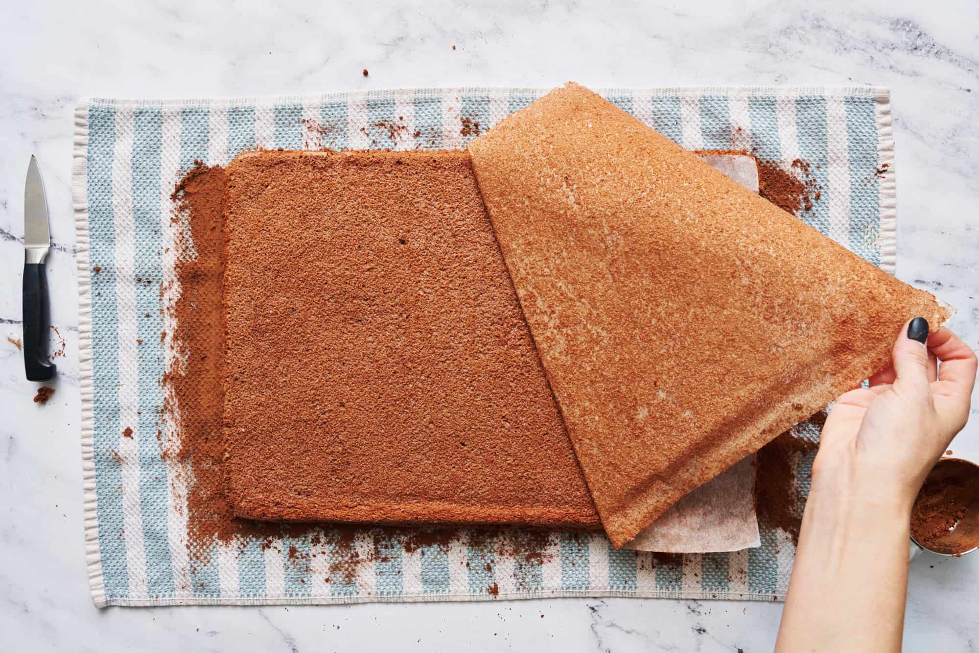 removing parchment paper from the bottom of the baked angel food cake sheet