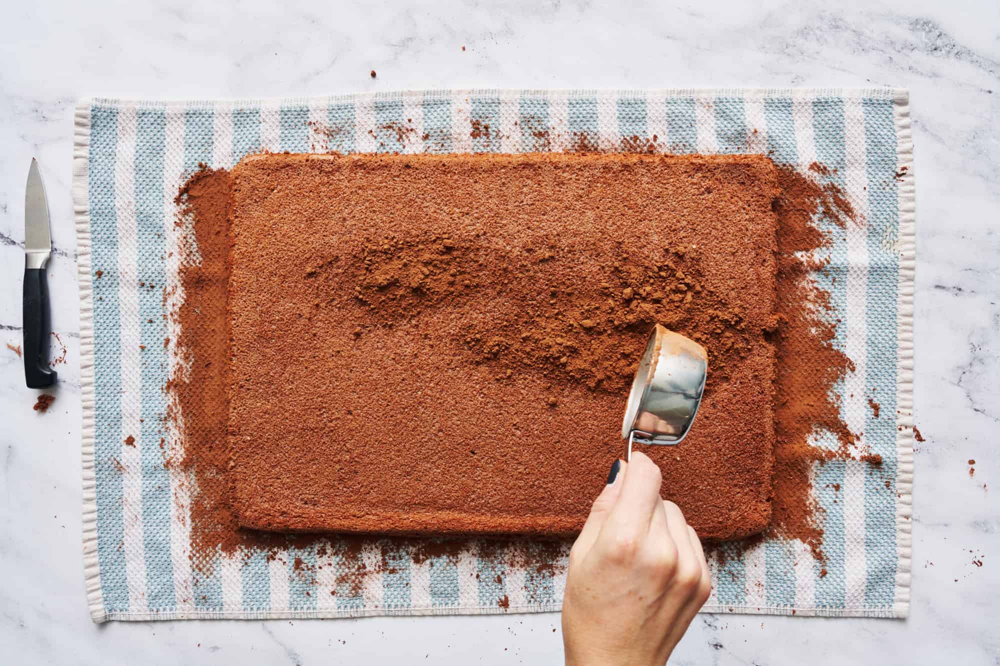 adding cocoa powder to prevent the cake from sticking when you roll it up