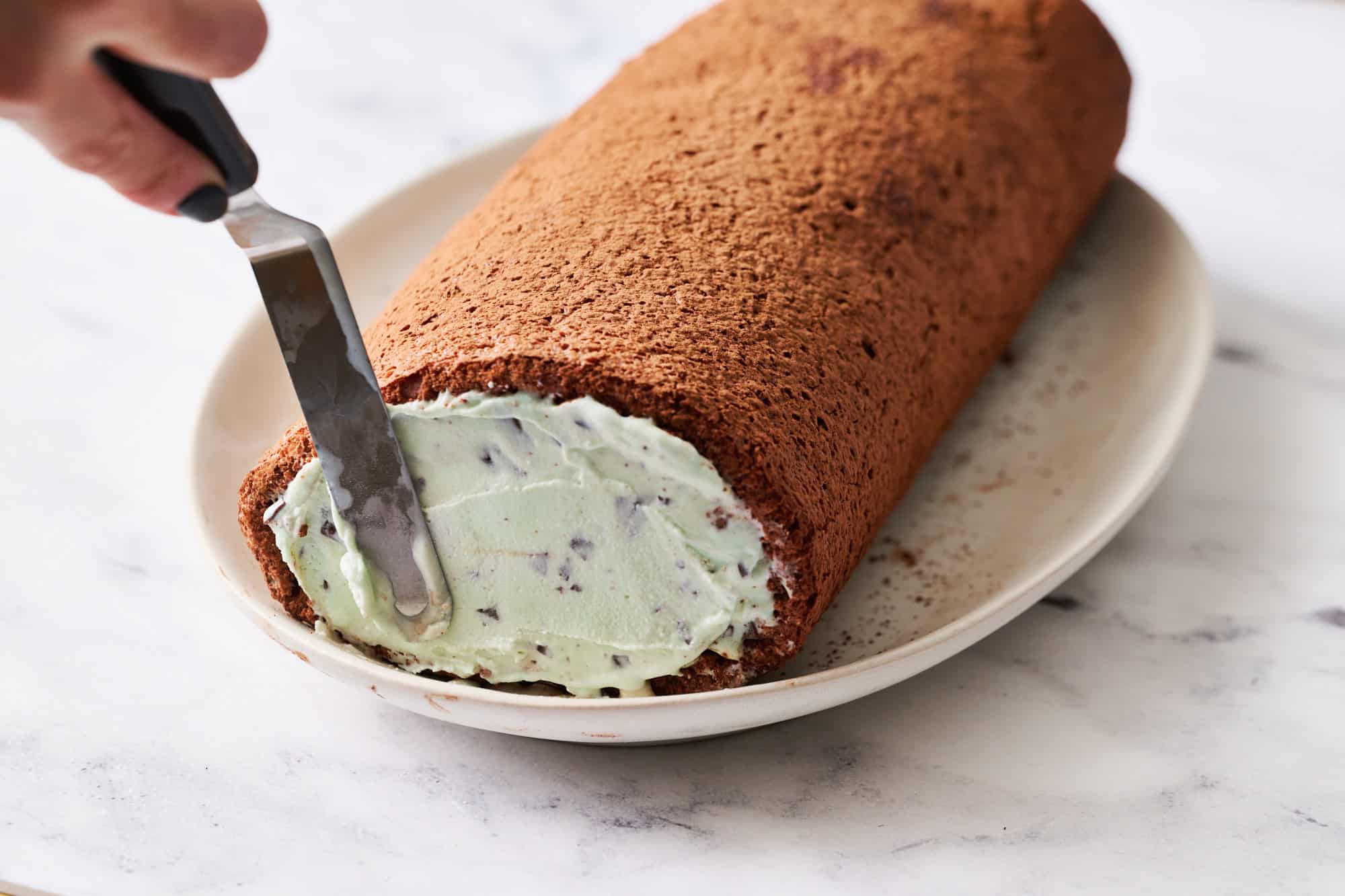 adding more ice cream to the ends of the ice cream yule log cake