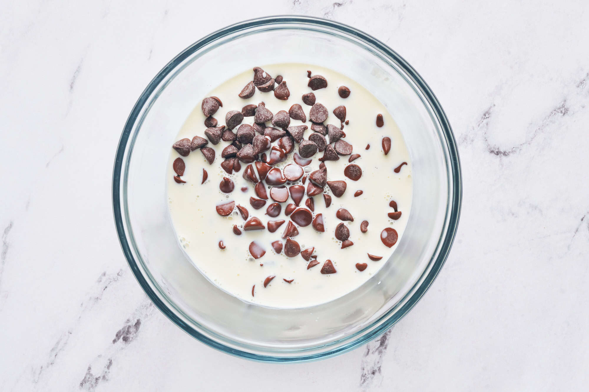 chocolate chips in hot cream to make ganache