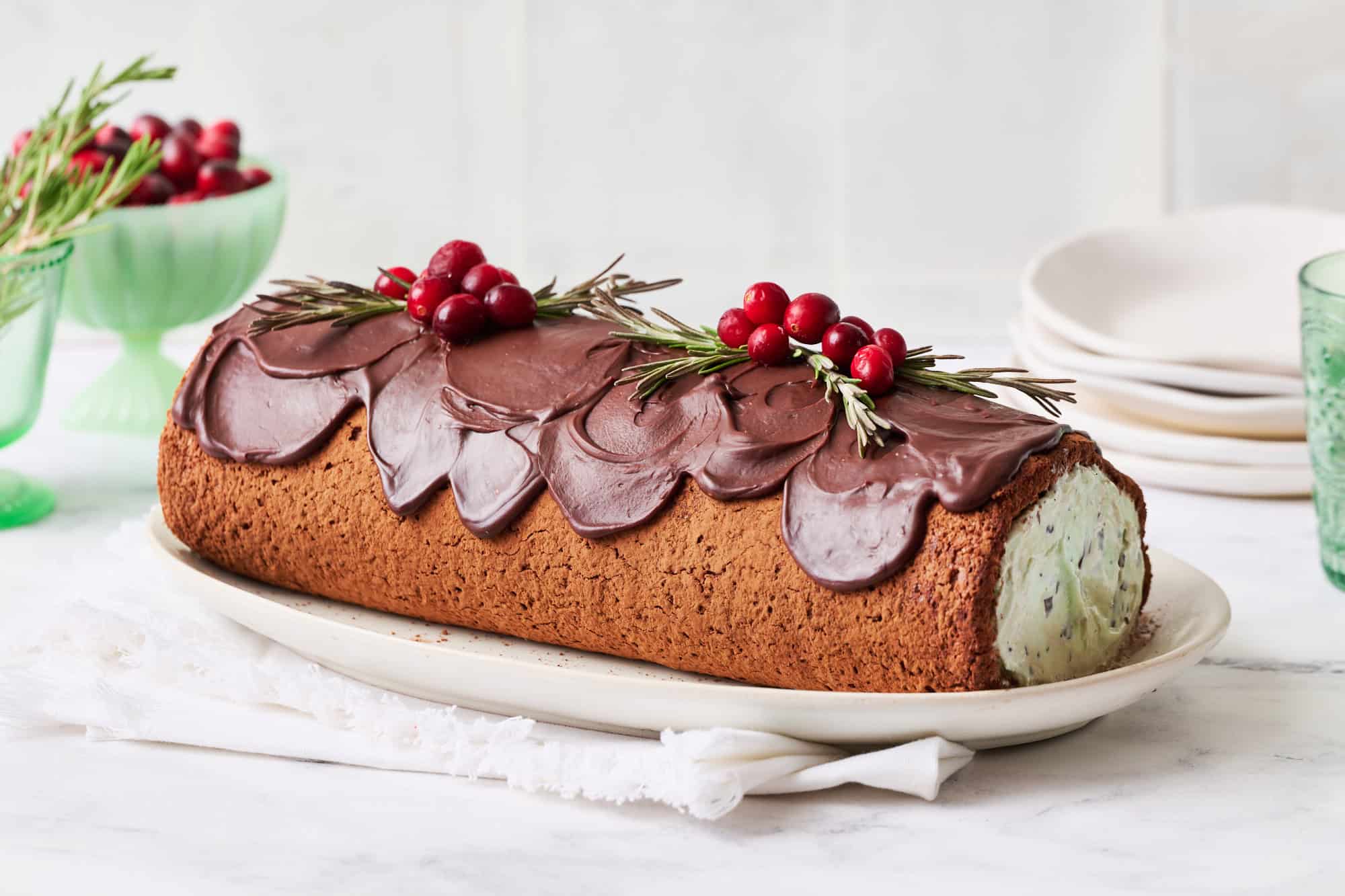 an ice cream yule log cake on a countertop ready to be sliced