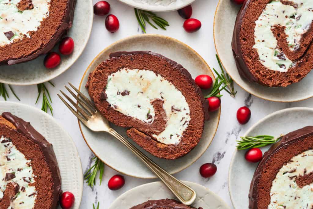 slices of ice cream yule log cake on dessert plates with a fork