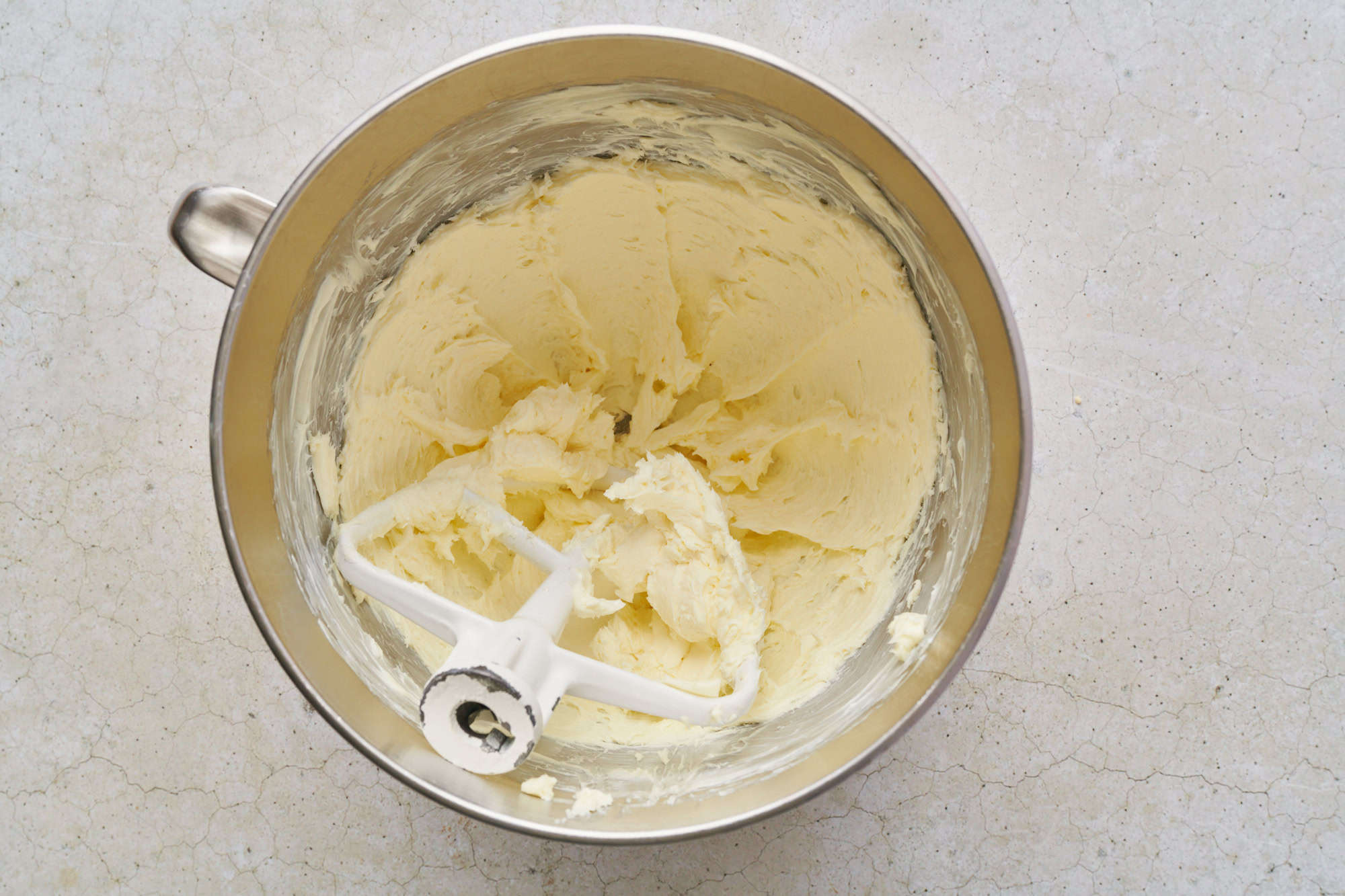 whipped butter in a metal bowl with a paddle attachment