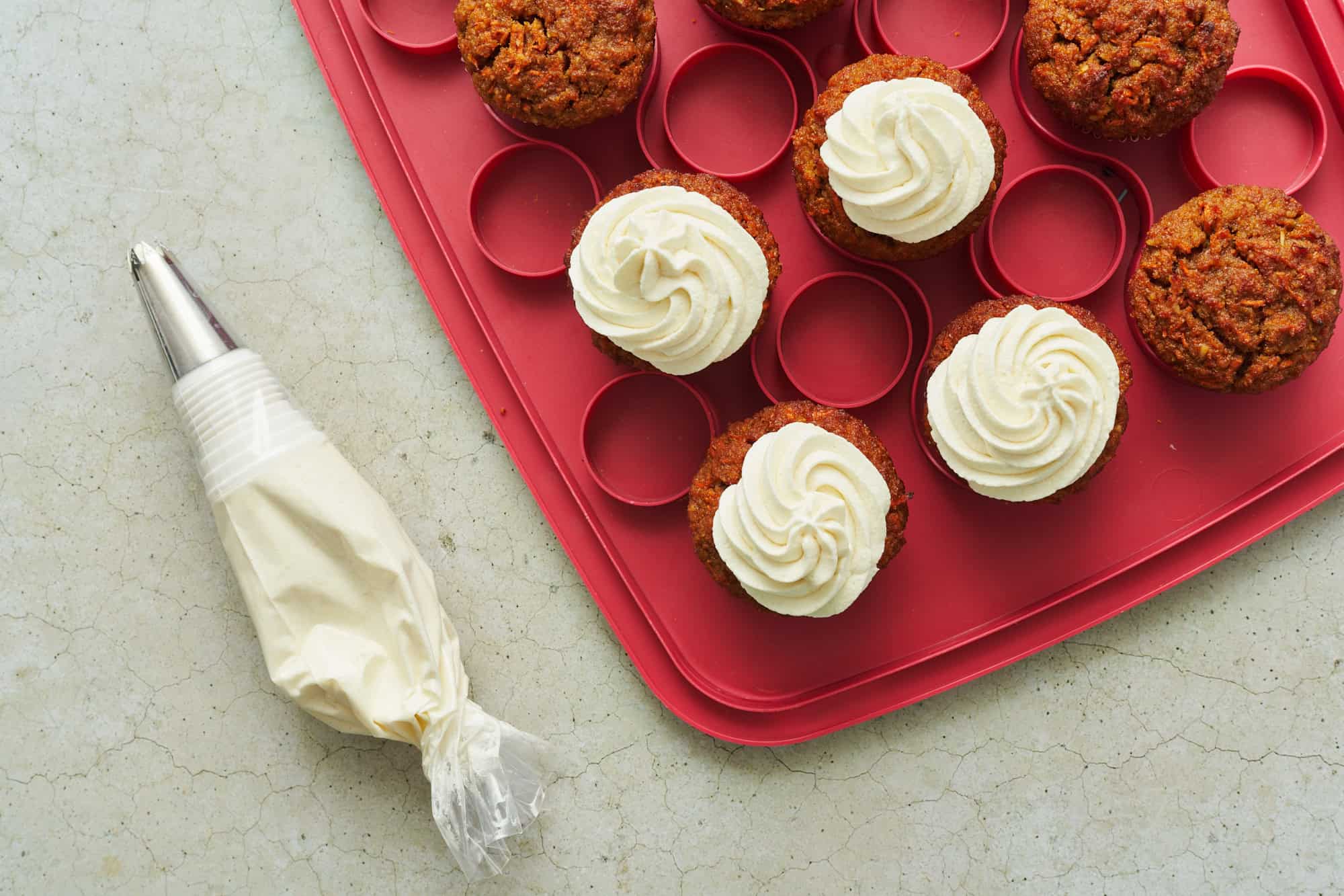 cupcakes on a cupcake platter with a piping bag with a star tip attached