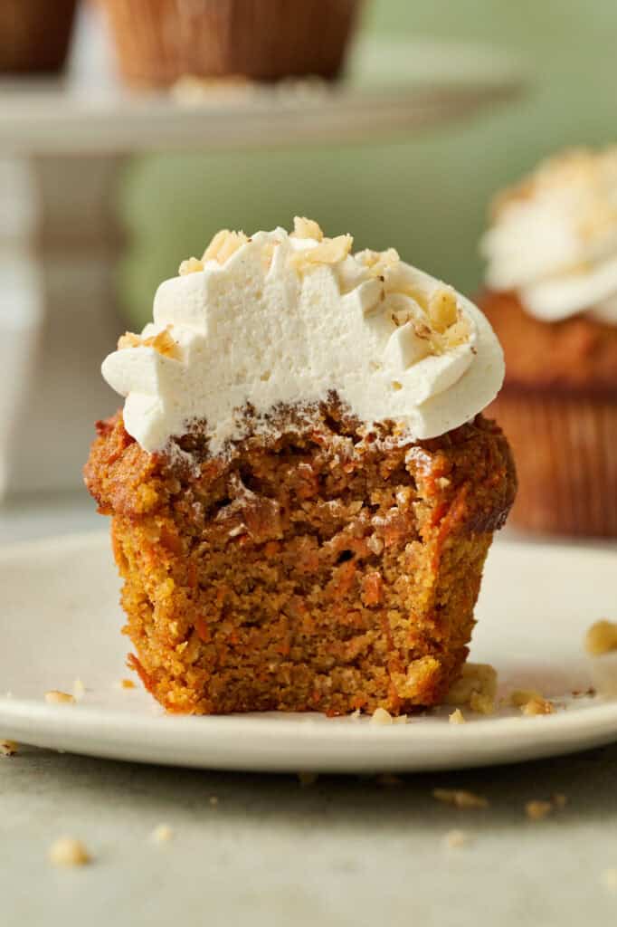 a carrot cake cupcake with a bite taken out