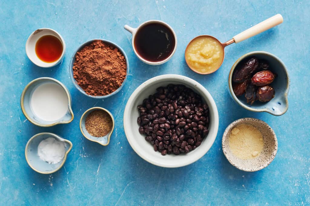 ingredients for Black bean Brownies including dates, almond flour, beans, applesauce, coffee, cocoa, flax, coconut milk, allulose and vanilla