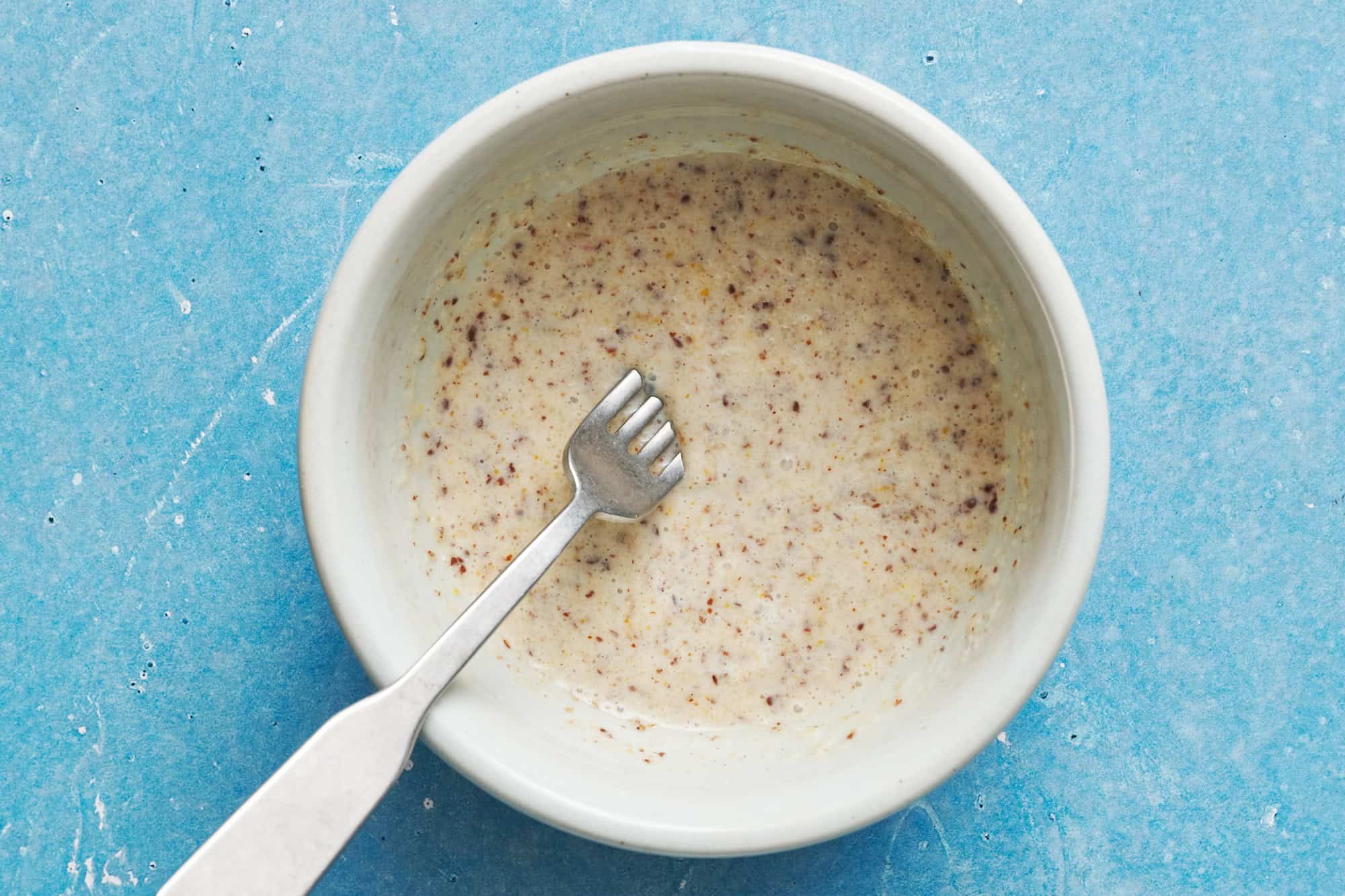 wet ingredients combined with flax and almond flour in a white bowl