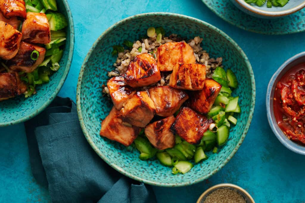 overhead view of a bowl filled with miso salmon, cucumber, scallions and quinoa