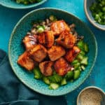 overhead view of a bowl filled with miso salmon, cucumber, scallions and quinoa