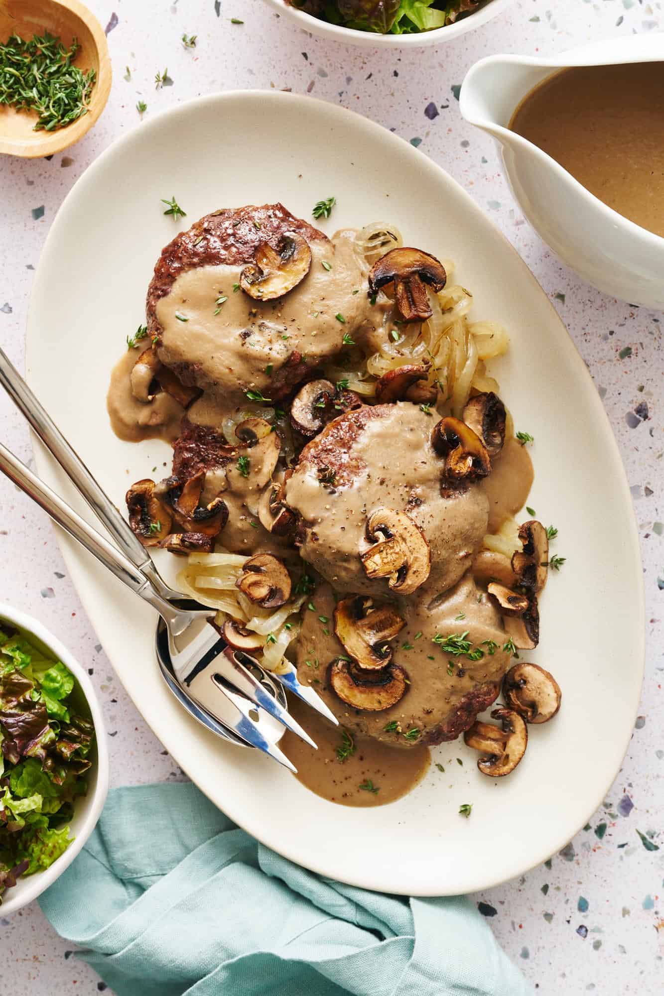 overhead of a platter with hamburger steaks smothered with mushroom gravy and onions