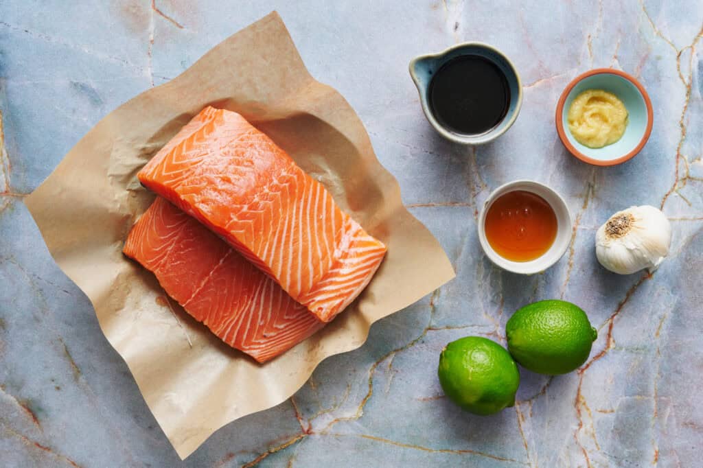 ingredients for salmon bites including ginger, soy sauce, honey, garlic, lime and salmon