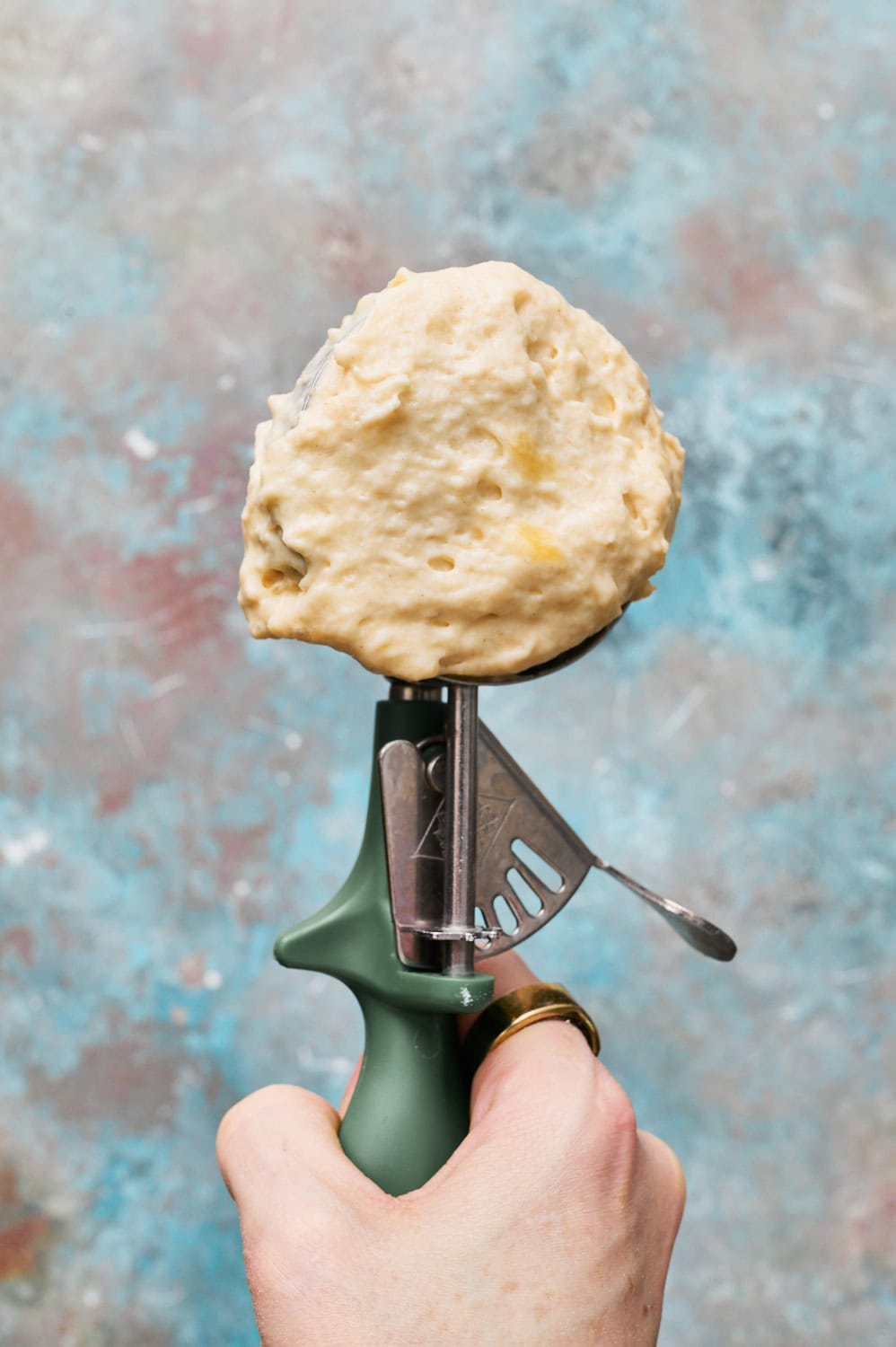 A kitchen scoop with batter in it ready to go on the waffle iron