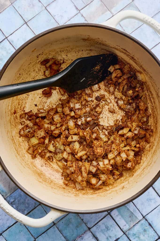 sauteing the aromatic spices and onion in a dutch oven