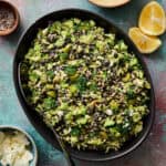 lentil broccoli salad in a large serving bowl with dressing on the side