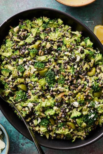 lentil broccoli salad in a large serving bowl with dressing on the side