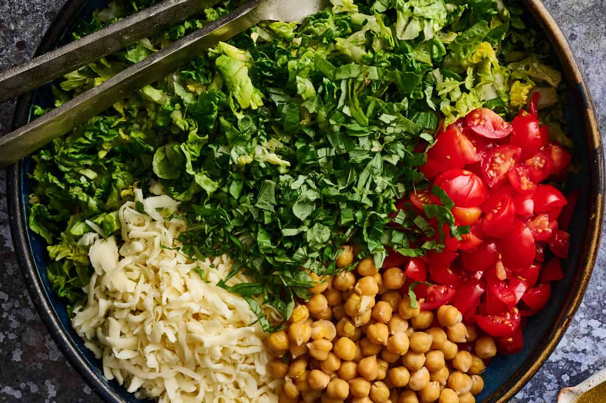 All the salad ingredients in a large bowl ready to be tossed with dressing