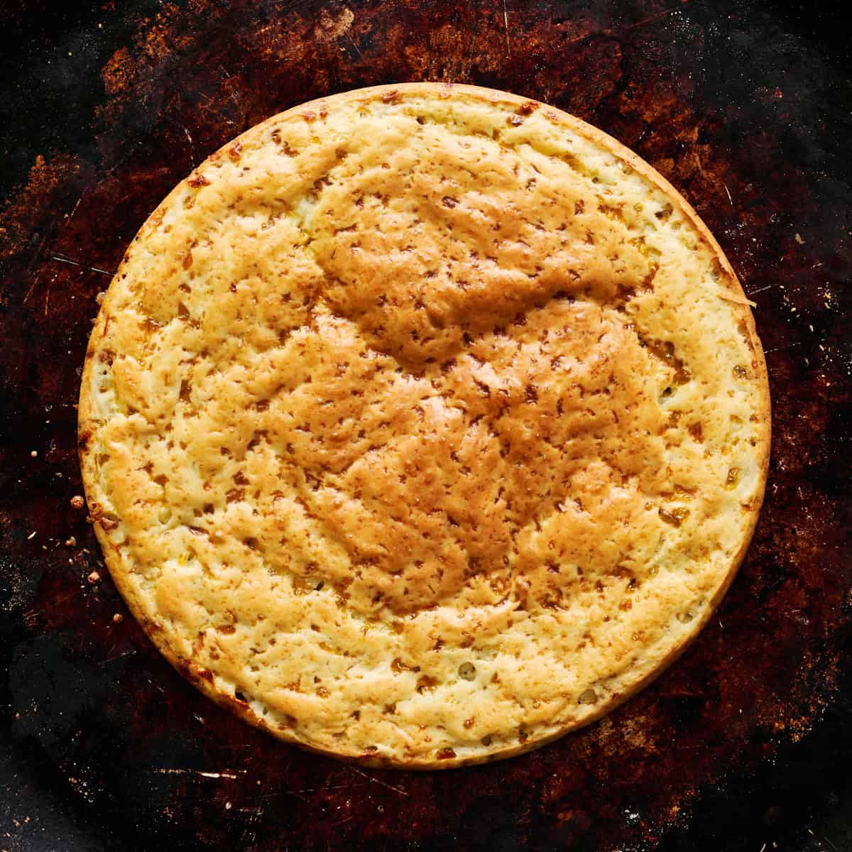 the crust removed from the cake pan and placed on a sheet tray ready for toppings