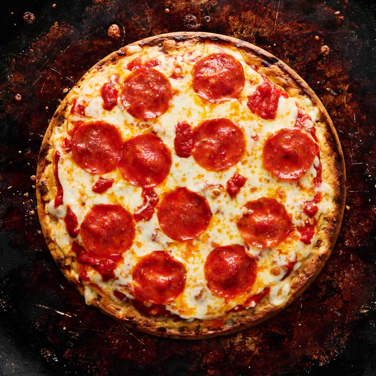 The finished pizza with melty cheese and crispy pepperoni on a metal baking tray