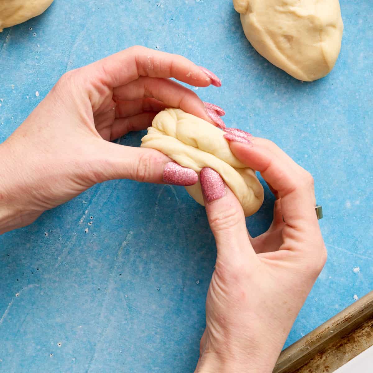 fingers smashing together edges of the dough ball