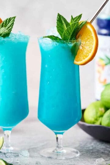 finished garnished Blue Ocean Mocktail drink with orange and mint