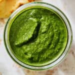 green chutney in a glass jar with naan bread