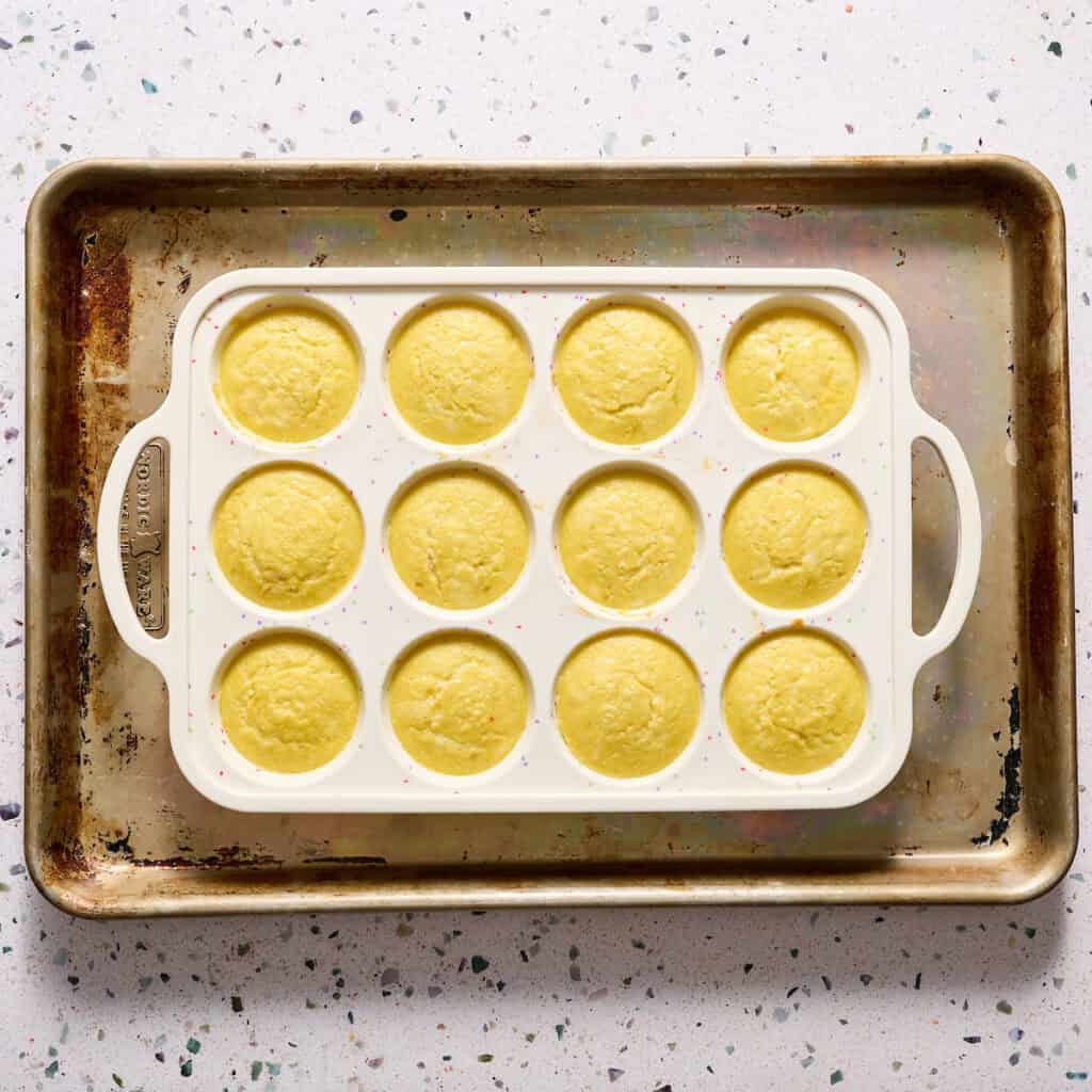 egg bites in a silicone muffin tin on a sheet tray after being baked