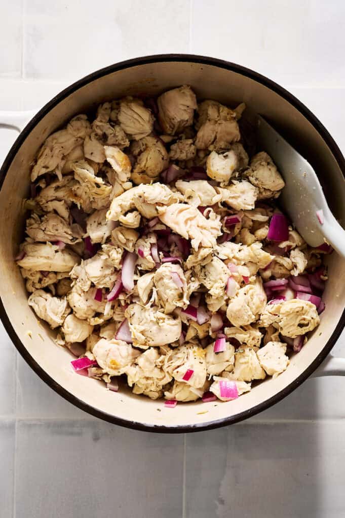 chicken and onion being cooked in a pot