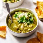 a bowl of chile verde with chips on the side