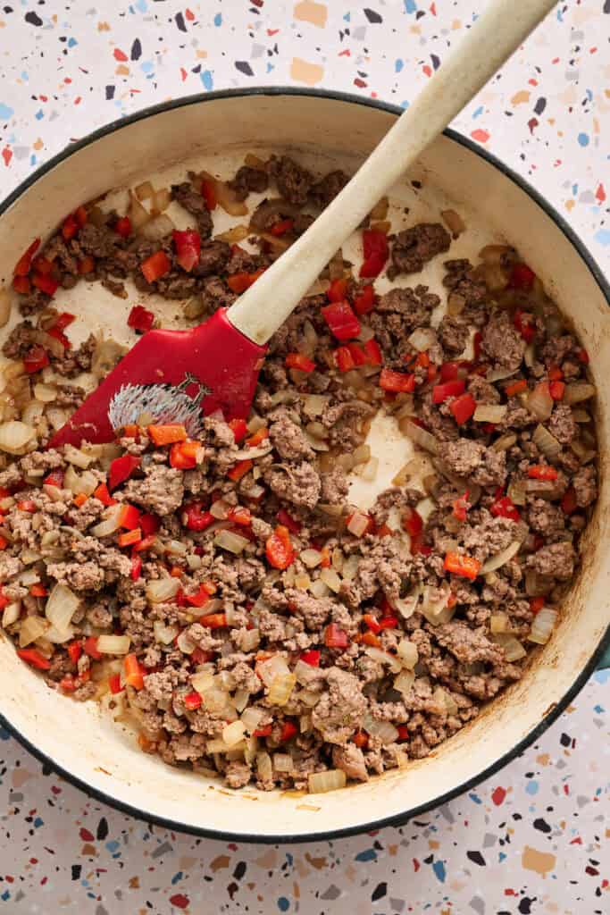 ground beef cooked in a pan with onions and peppers