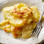 instant pot scalloped potatoes served on a plate with a fork next to it
