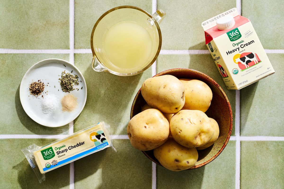 ingredients for instant pot scalloped potatoes: cream, potatoes, broth, spices, cheddar cheese