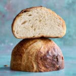 a loaf of sourdough bread sliced in half showing top and open crumb