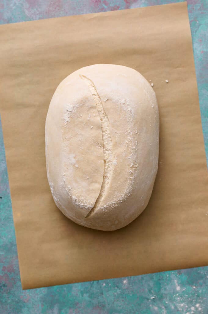 proofed sourdough loaf of bread that's been scored with a lame