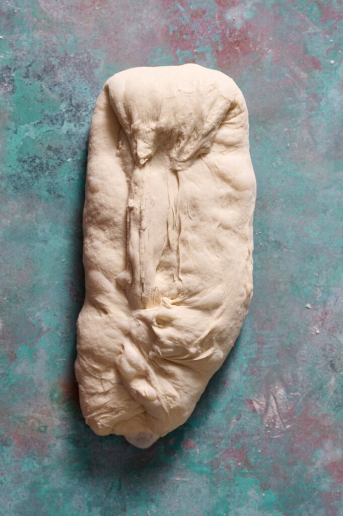 folding the sheet of dough into a rectangle to create layers in the final loaf