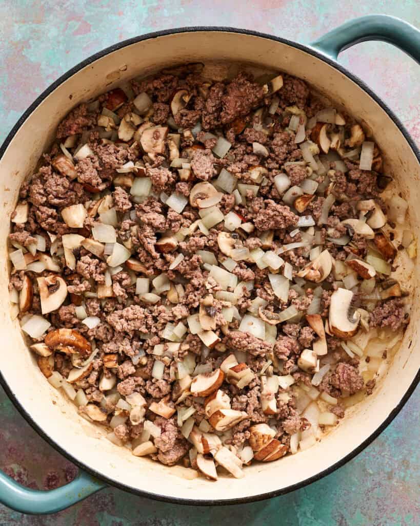 ground beef sauteed with onions and mushrooms in a pot