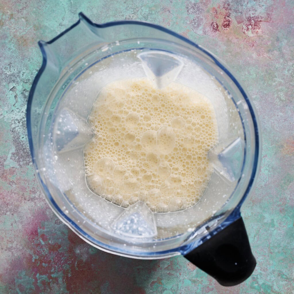 wet ingredients blended with a banana in a blender