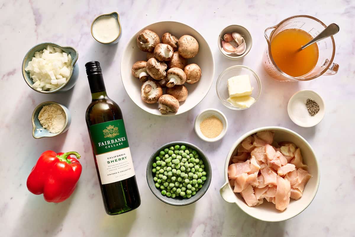 ingredients to make chicken a la king including sherry, chicken, peas, bell pepper, mushrooms and broth
