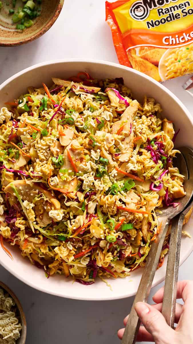 ramen noodle salad in a large serving bowl with tongs