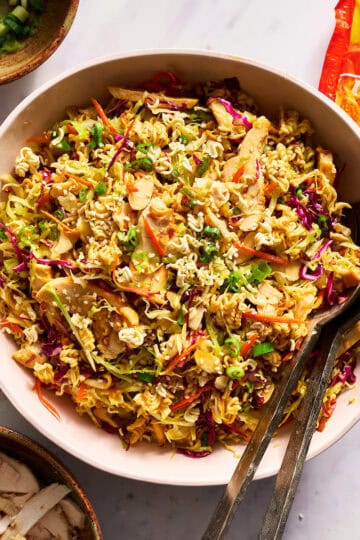 ramen noodle salad in a large serving bowl with tongs