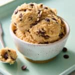cottage cheese cookie dough scooped into a bowl with extra chocolate chips